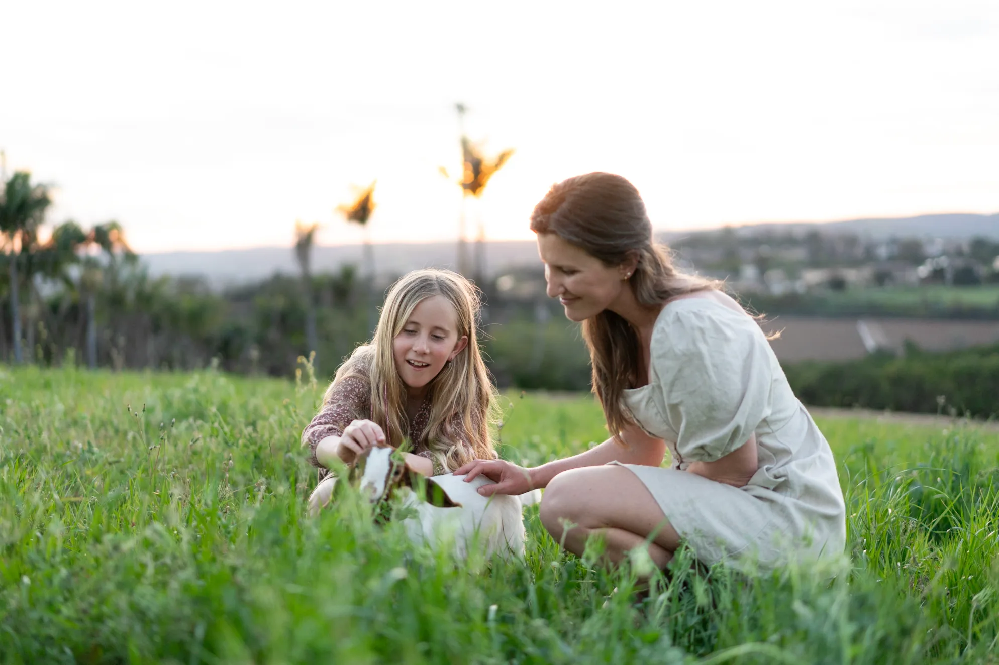 A mother and daughter with butterflies in the tall grass