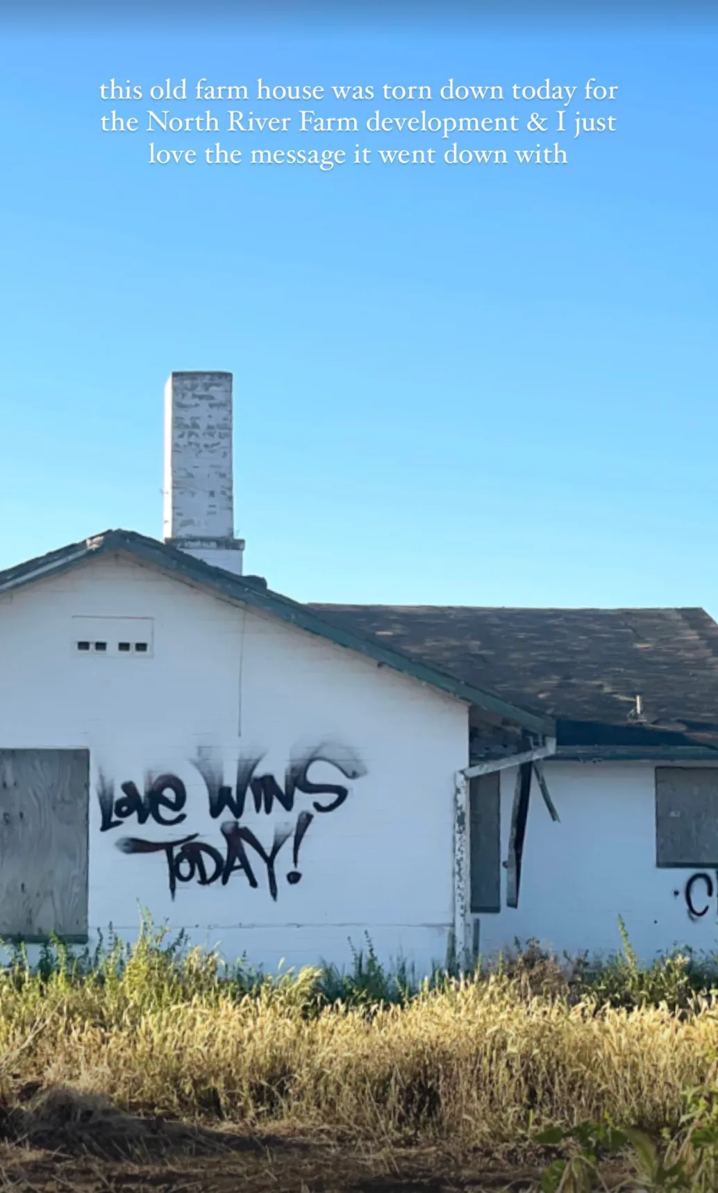An old farmhouse with ‘love wins today’ painted on its wall, days before it was torn down