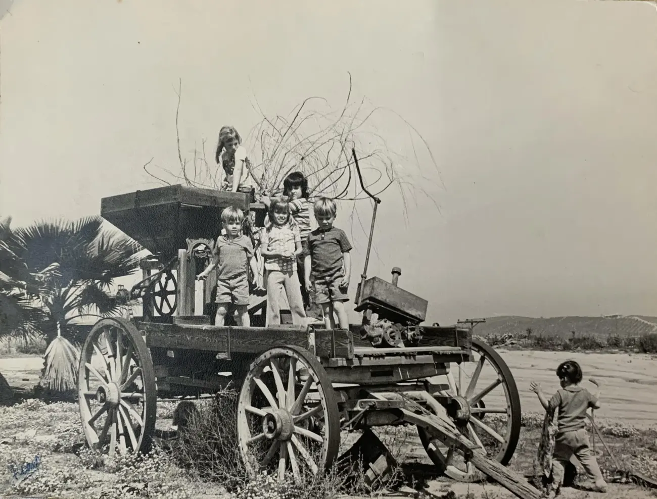 A neighbor and her siblings playing on the old farm wagon in the early 1970s